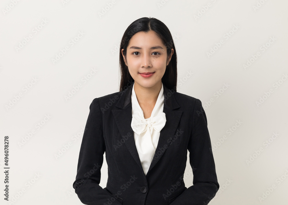 Young asian business woman smiling to camera standing pose on isolated white background. Female around 25 in suit portrait shot in studio. Young asian business woman smiling to camera standing pose on isolated white background. Female around 25 in suit portrait shot in studio.