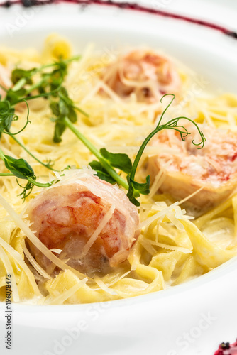 Pasta with grilled shrimps, bechamel sauce, cheese and microgreen, italian cuisine, Food recipe background. Close up. vertical image. top view. place for text