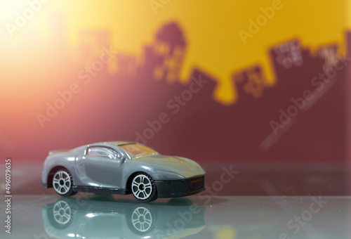 Fototapeta Naklejka Na Ścianę i Meble -  dark grey saloon car toy selective focus on blur city background