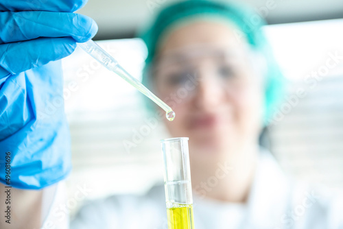 Wissenschaftlerin im Labor mit Pipette und Reagenzglase photo