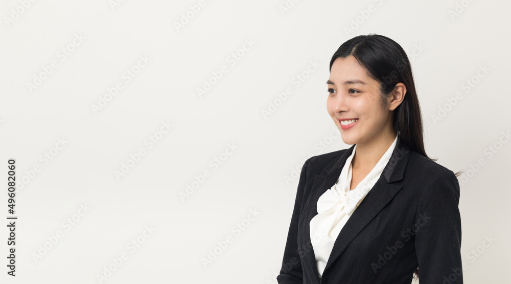 Young asian business woman smiling standing looking at blank space on isolated white background. Female around 25 in suit portrait shot in studio. Young asian business woman smiling standing looking at blank space on isolated white background. Female around 25 in suit portrait shot in studio.
