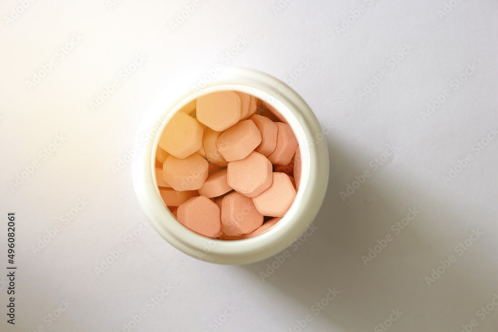 hexagon shape tablets in white plastic jar in medical healthcare drugstore concept,closed up hexagon shape tablets in white plastic jar in medical healthcare drugstore concept,closed up