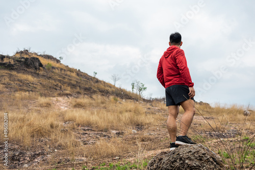 Rear view Trail runner man running on rocky mountain. Athlete jog exercising outdoor for healthy. Confident and powerful marathon man running workout and cardio. Sport and Lifestyle concept.