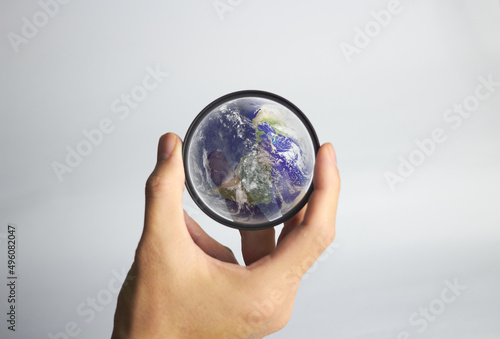 Hand holds clear lens camera filter on white background