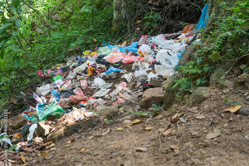 pile of plastic garbage in a backyard garden, environmental pollution with plastics and wastes, global warming and ecological problem concept