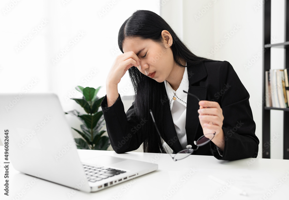 Young asian business woman rubbing her eyes she's feeling depressed stress headache be tired from working with laptop a long time she symptom office syndrome. Young asian business woman rubbing her eyes she's feeling depressed stress headache be tired from working with laptop a long time she symptom office syndrome.