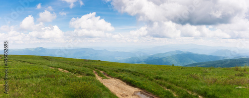 panoramic view of a summer hilly countryside. ukrainian carpathians mountain landscape. dirt road and hiking trail. ecosystem and healthy environment concept and background
