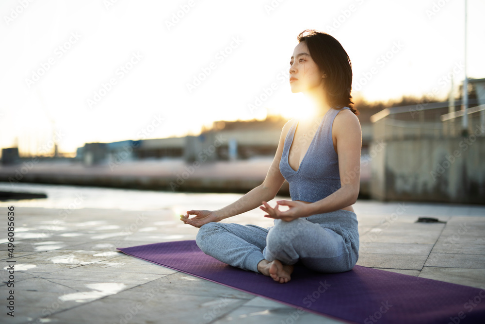 Beautiful young woman training outside. Fit woman doing stretching exercise..