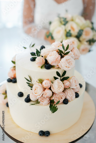 The wedding cake. Stylish happy newlyweds, elegant satisfied bride. Newlyweds gathering