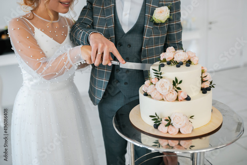 The wedding cake. Stylish happy newlyweds, elegant satisfied bride. Newlyweds gathering photo