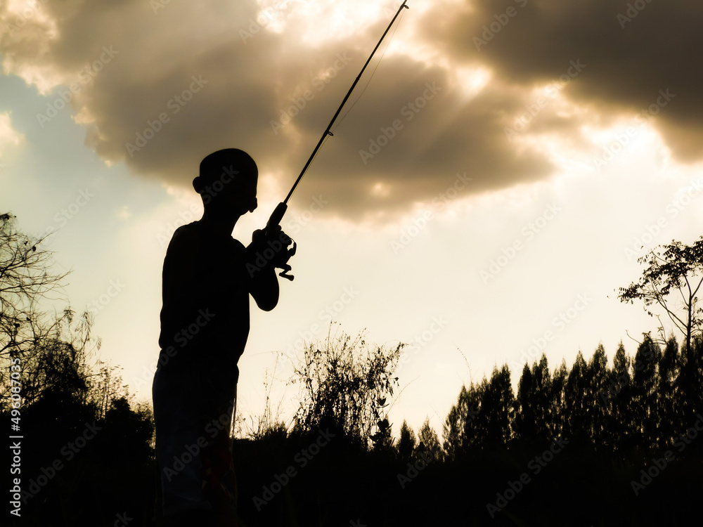 silhouette of a child fishing Children's happy time in the midst of nature at sunset