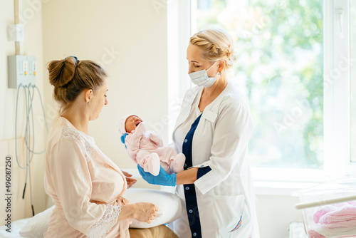 Breastfeeding consultant or doctor making notes in medical records  hospital examination  patient diagnosis while mother holding and breastfeeding infant baby at hospital.