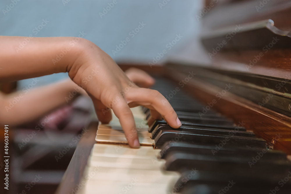 child's hands on piano keys, close-up photography