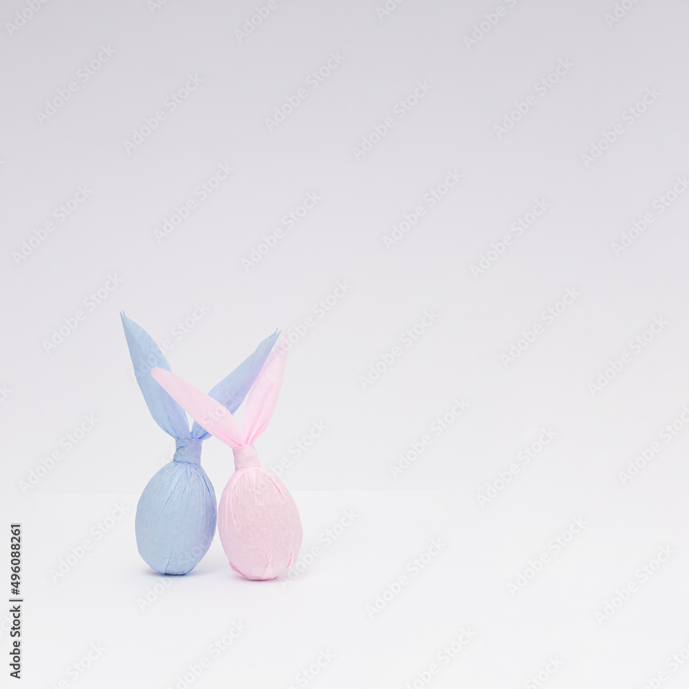 Fototapeta premium Easter bunny paper gift egg wrapping diy idea. Minimal Easter concept. With copy space.
