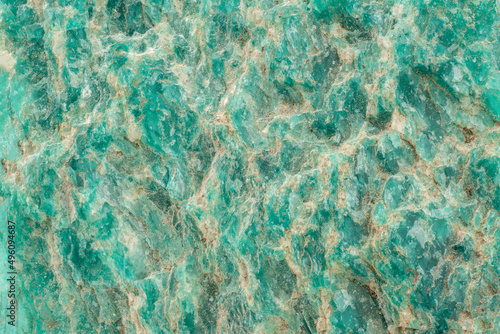 Amazonite is a bluish-green variety of microcline feldspar. Mineral amazonite. A structure of a rock on fracture close-up.  photo