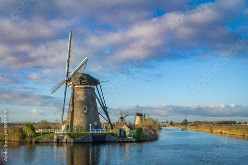 Holenderska wioska. Stary wiatrak przy kanale, piękne niebo, uroczy krajobraz.