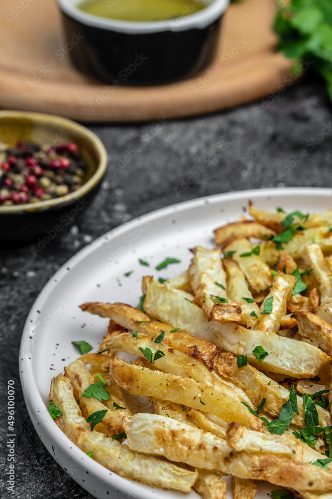 Oven roasted parsnips side dish on plate. Delicious vegetarian breakfast or snack, Clean eating, dieting, vegan food concept. vertical image. top view. place for text,