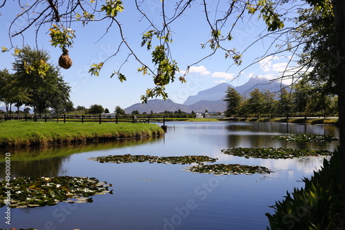 A view over a dam on a farm near Worcester, South Africa. It is surrounded by lawns and trees  with beautiful reflections on the surface. photo