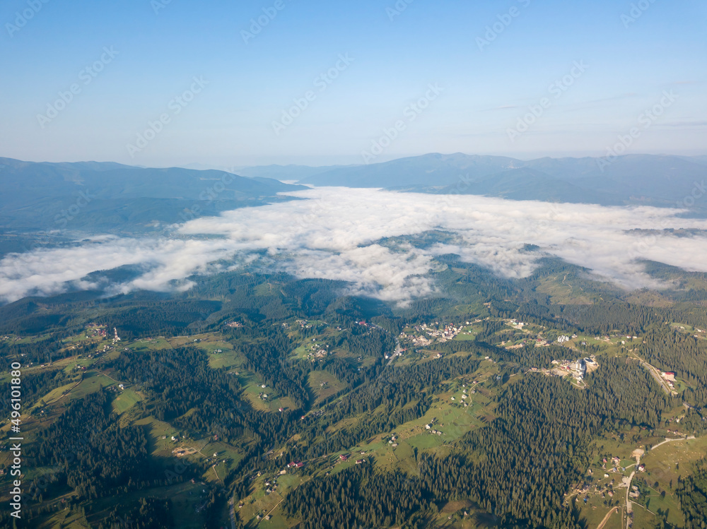 High flight in the mountains of the Ukrainian Carpathians. Fog in the valley. Aerial drone view.