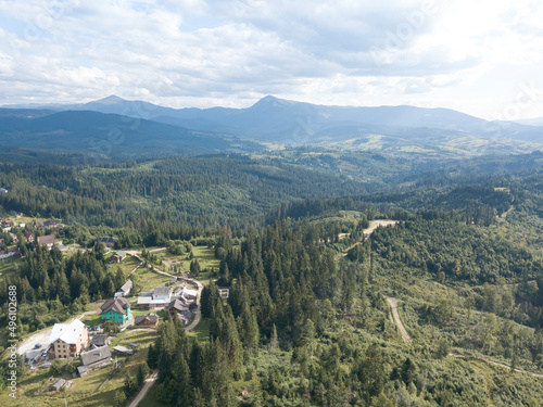 Green mountains of Ukrainian Carpathians in summer. Coniferous trees on the slopes. Aerial drone view.