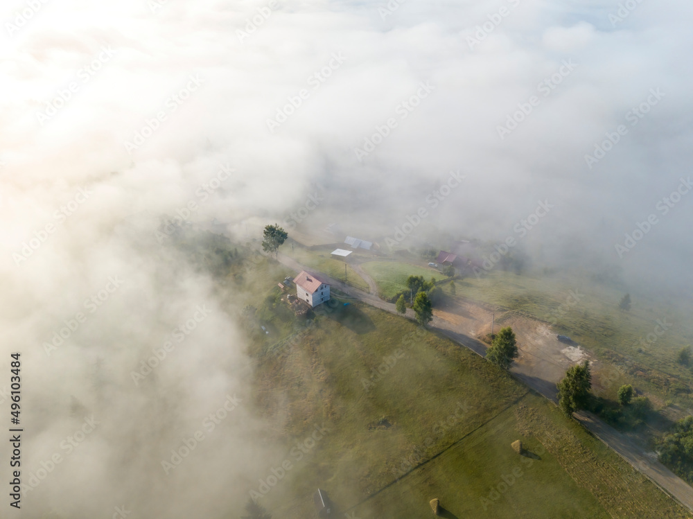 Mountain settlement in the Ukrainian Carpathians in the morning mist. Aerial drone view. Mountain settlement in the Ukrainian Carpathians in the morning mist. Aerial drone view.