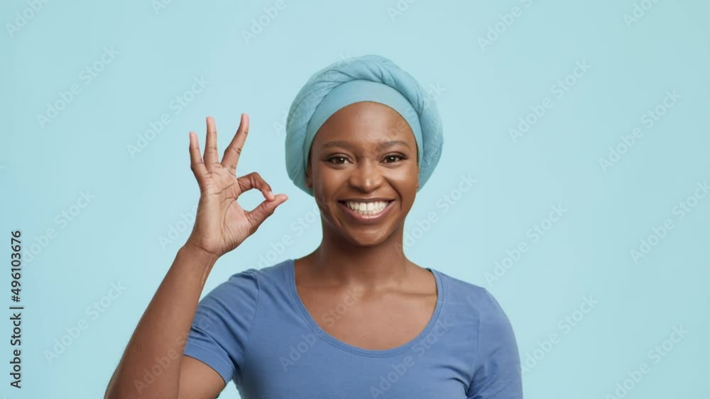 African American Lady Gesturing And Saying OK Over Blue Background African American Lady Gesturing And Saying OK Over Blue Background