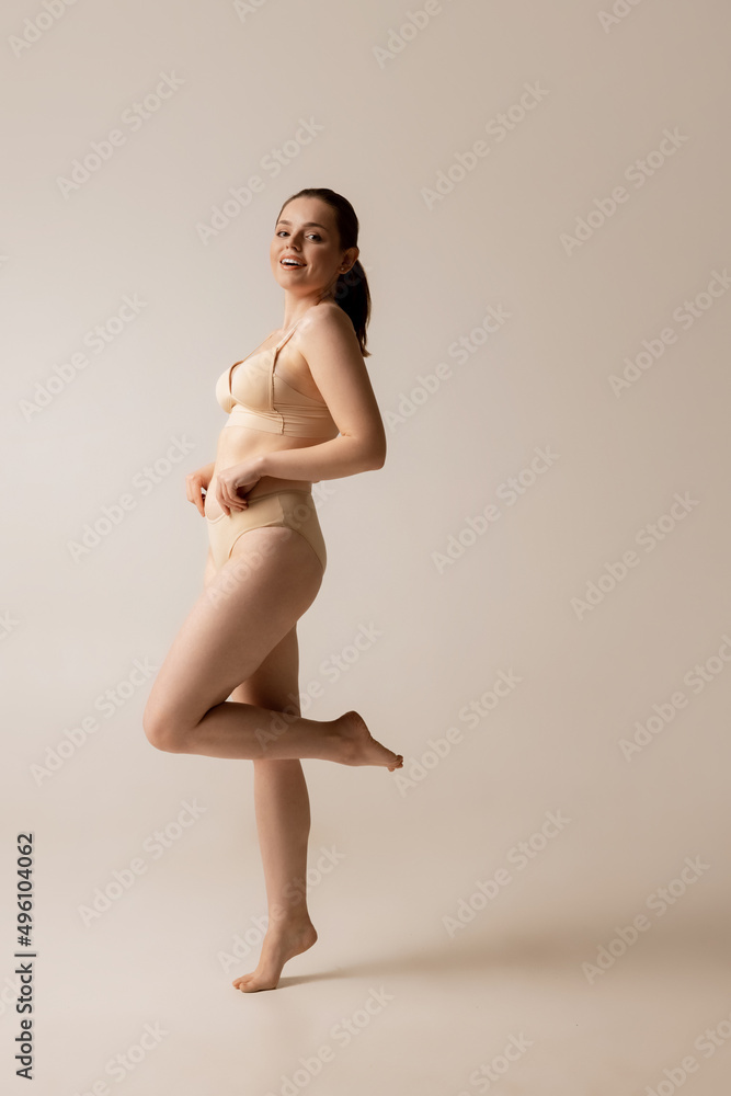 Portrait of a young woman wearing underwear, full length stock