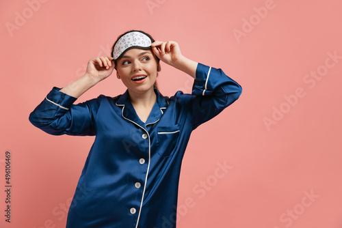 Foto Half-length portrait of young cheerful woman in silk pajamas wearing sleeping ma