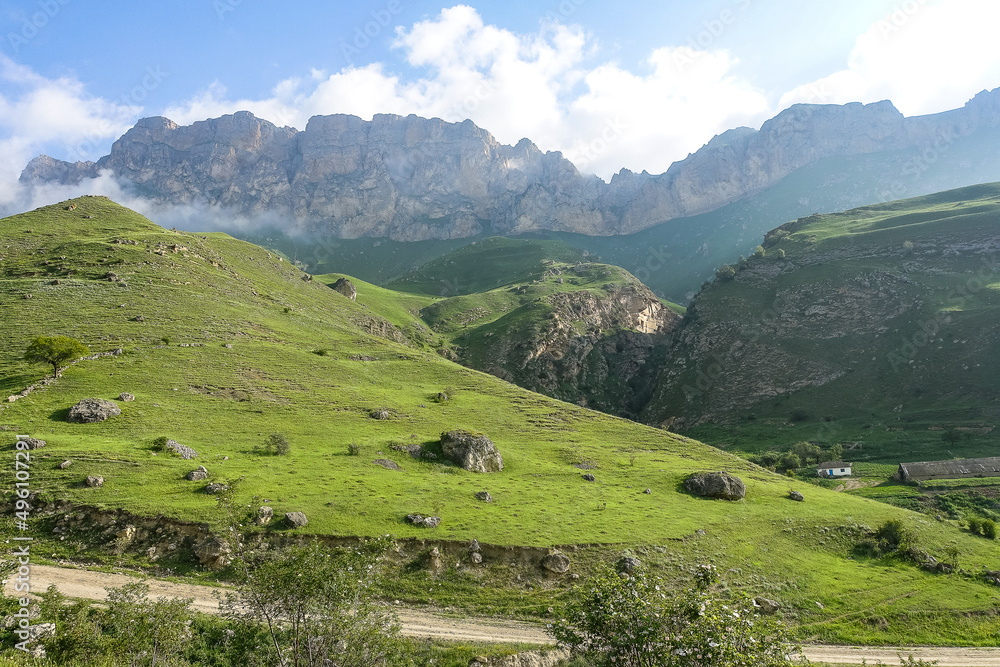 The landscape of the green Aktoprak pass in the Caucasus, the road and the mountains under gray clouds. Kabardino-Balkaria, Russia The landscape of the green Aktoprak pass in the Caucasus, the road and the mountains under gray clouds. Kabardino-Balkaria, Russia