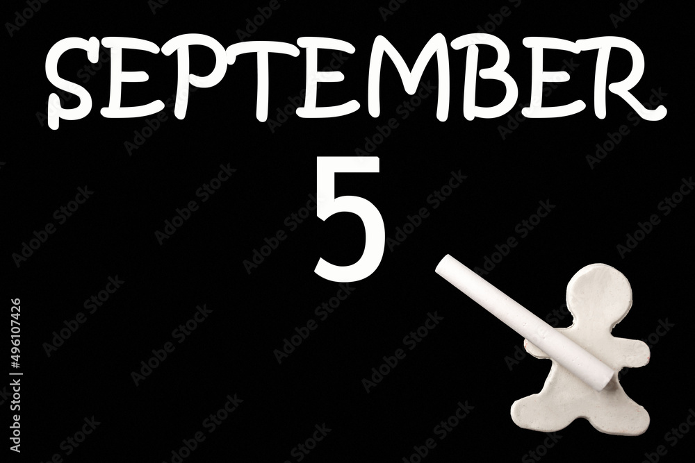A small white plasticine man writing the date 5 September on a black board. Business concept. Education concept. A small white plasticine man writing the date 5 September on a black board. Business concept. Education concept.