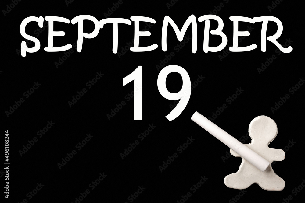 A small white plasticine man writing the date 19 September on a black board. Business concept. Education concept. A small white plasticine man writing the date 19 September on a black board. Business concept. Education concept.