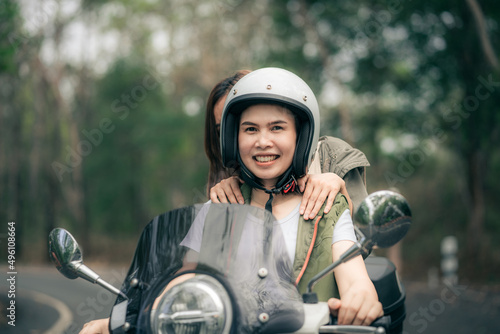 Beautiful woman riding a motor scooter on road. Travels by scooter with a friend slow life in the countryside on vacation.