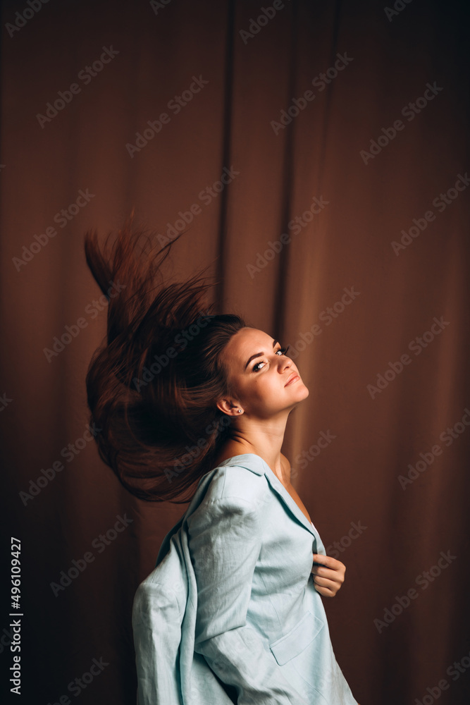 The girl in the blue jacket throws her long hair. Portrait of a beautiful smiling girl The girl in the blue jacket throws her long hair. Portrait of a beautiful smiling girl