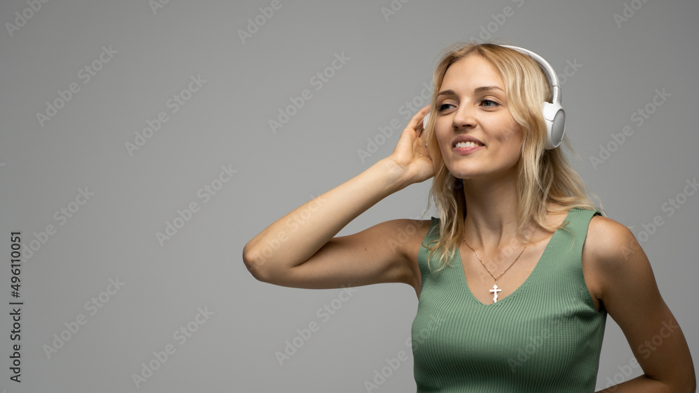 Beautiful blonde girl in green t-shirt in headphones having fun in studio dancing and laughing. Beautiful blonde girl in green t-shirt in headphones having fun in studio dancing and laughing.