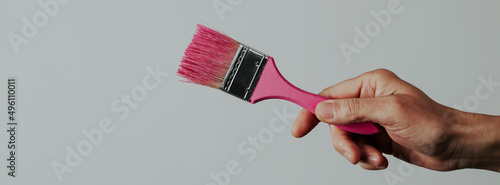 Fotografie, Obraz man grabs a paintbrush with pink paint, banner