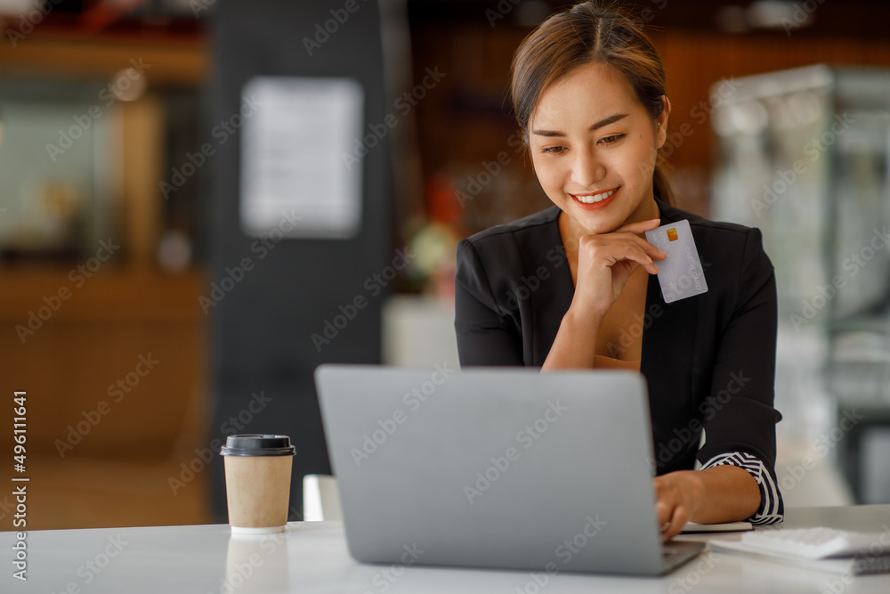 Asian businesswoman use credit cards and laptop computers mobile smartphones for payments and online shopping, Online shopping, digital banking, E-commerce credit card concept. Asian businesswoman use credit cards and laptop computers mobile smartphones for payments and online shopping, Online shopping, digital banking, E-commerce credit card concept.