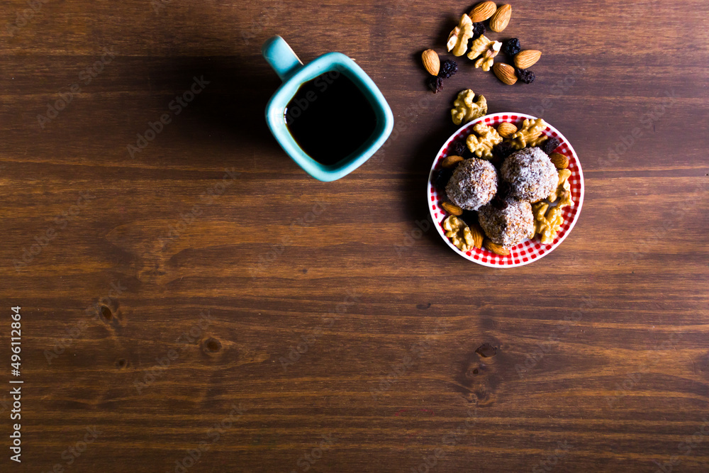 Bodegón de cafés con bombones y frutos secos sobre mueble de madera marrón. Naturaleza muerta. Bodegón de cafés con bombones y frutos secos sobre mueble de madera marrón. Naturaleza muerta.