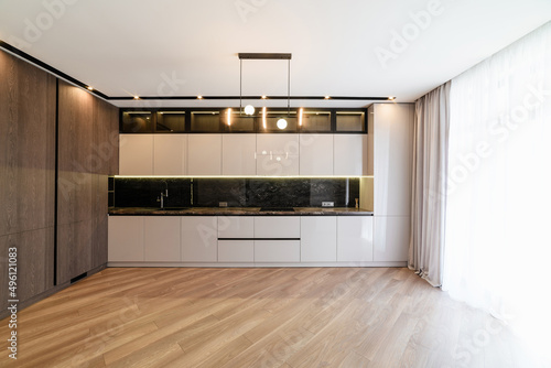 new interior of a white kitchen in a house with dark floors