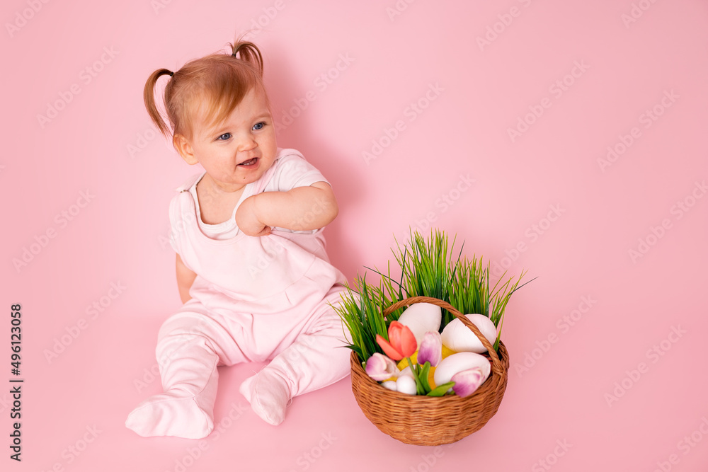 Charming happy little girl in a pink jumpsuit and with bunny ears on her head, laughing, on a pink background Charming happy little girl in a pink jumpsuit and with bunny ears on her head, laughing, on a pink background
