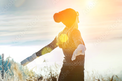 Happy female traveler resting on top of mountain under blue sky