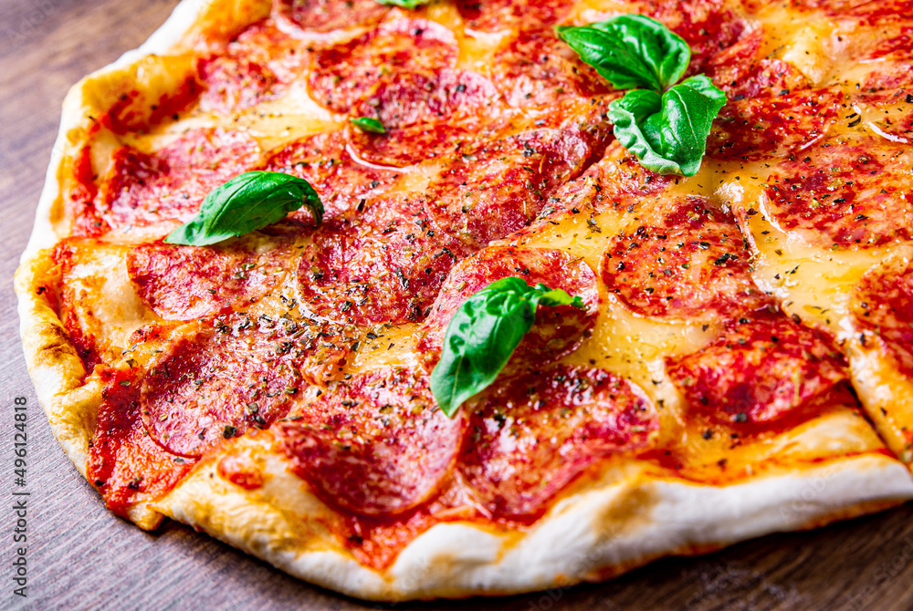 Pepperoni Pizza with Mozzarella cheese, salami, Tomato sauce, pepper, Spices and Fresh basil. Italian pizza on wooden table background Pepperoni Pizza with Mozzarella cheese, salami, Tomato sauce, pepper, Spices and Fresh basil. Italian pizza on wooden table background