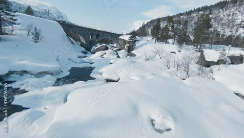 Wallpaper Mural Majestic icy river and bridge in winter landscape of Norway. FPV drone fly under bridge Torontodigital.ca