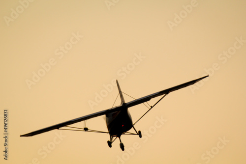 Ein Kleinflugzeug fliegt Richtung Sonnenuntergang. 