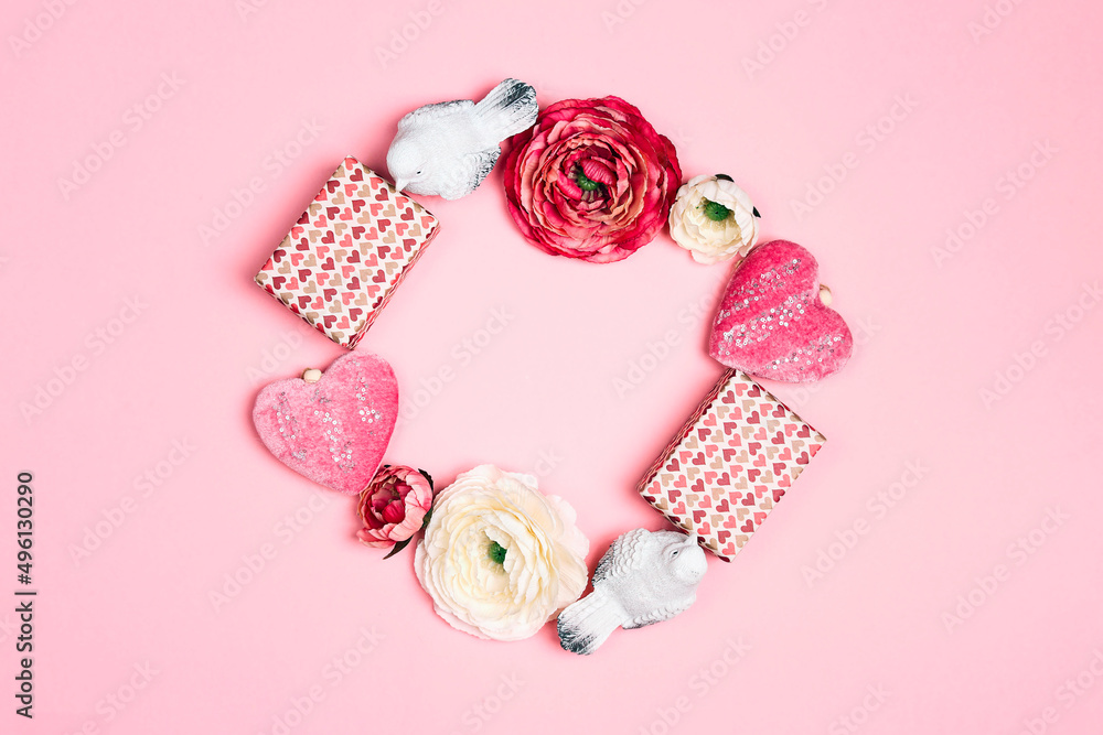 Romantic round frame of gifts, flowers, birds and decorative hearts on pink background. Place for text, top down composition. Romantic round frame of gifts, flowers, birds and decorative hearts on pink background. Place for text, top down composition.