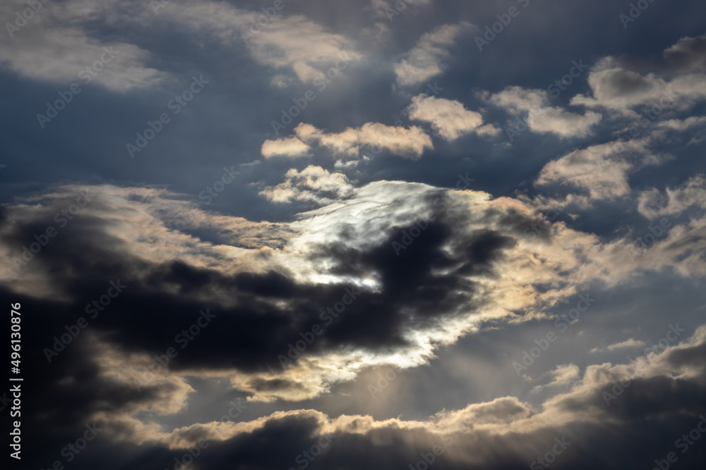 beautiful spring sky, covered with big clouds. extremely amazing, dramatic and apocalyptic sky and the sun and sunny rays. the sun is shining through dark clouds. sunshine. sunset