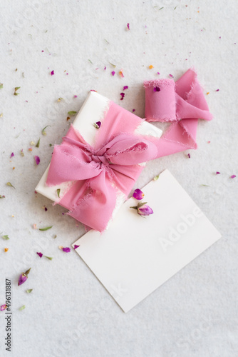 Top view of beautifully wrapped gift box decorated with pink silk ribbon.
