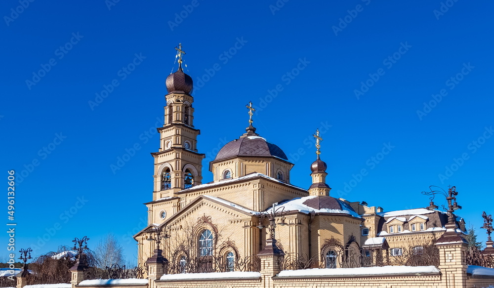 The building of the Orthodox church on the background of blue sky with white clouds in winter. Russia. Ural. Kurganovo