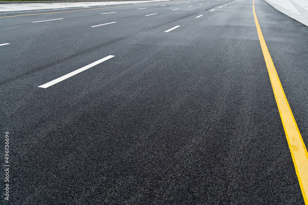 Asphalt road with white stripes and yellow lines