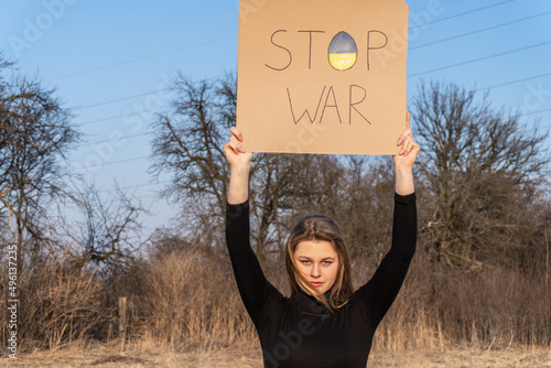 The  girl calls to Stop war, holding banner with inscription stop the war. No war. Stop war.  Stop the war in Ukraine. The concept of peace in Ukraine. Selective focus