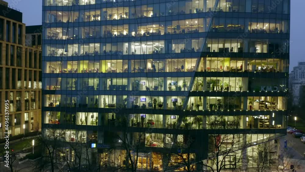 Drone shot at the windows of offices in a skyscraper at night in winter. Drone shot at the windows of offices in a skyscraper at night in winter.